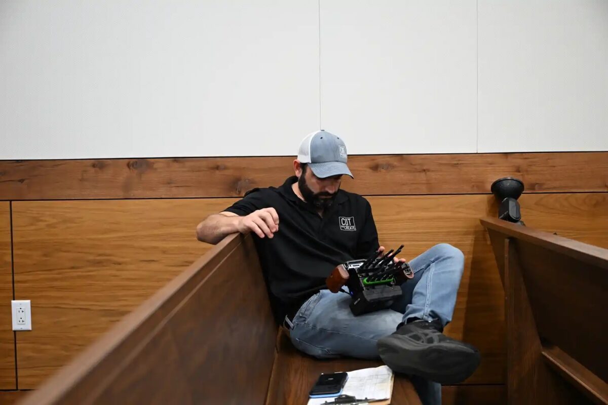 Crew member reviewing wireless monitor during courtroom shoot