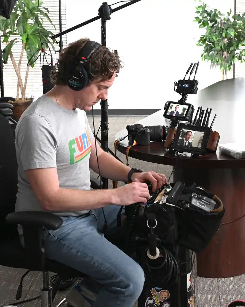 Crew member monitoring audio and camera feed during attorney interview