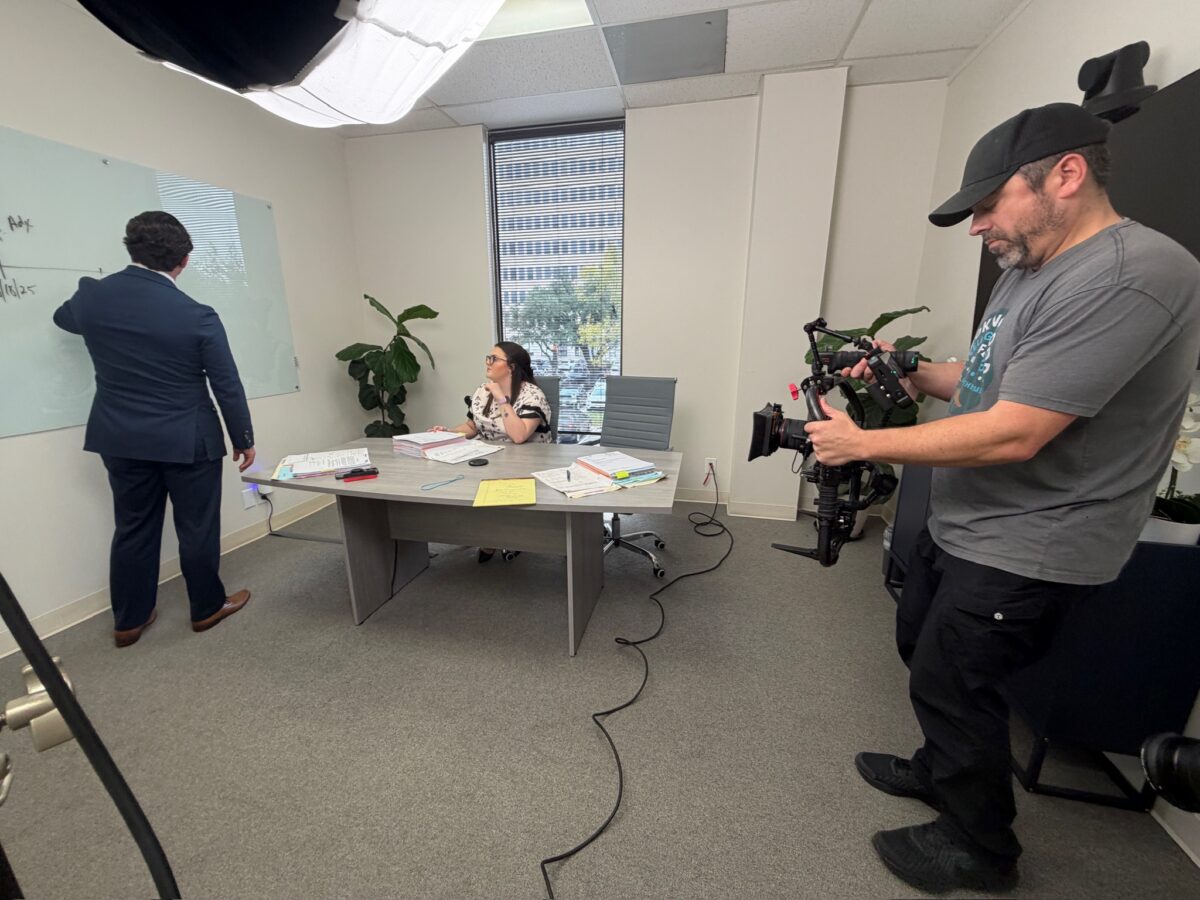 Camera operator filming a staged office scene for Funk Law Group