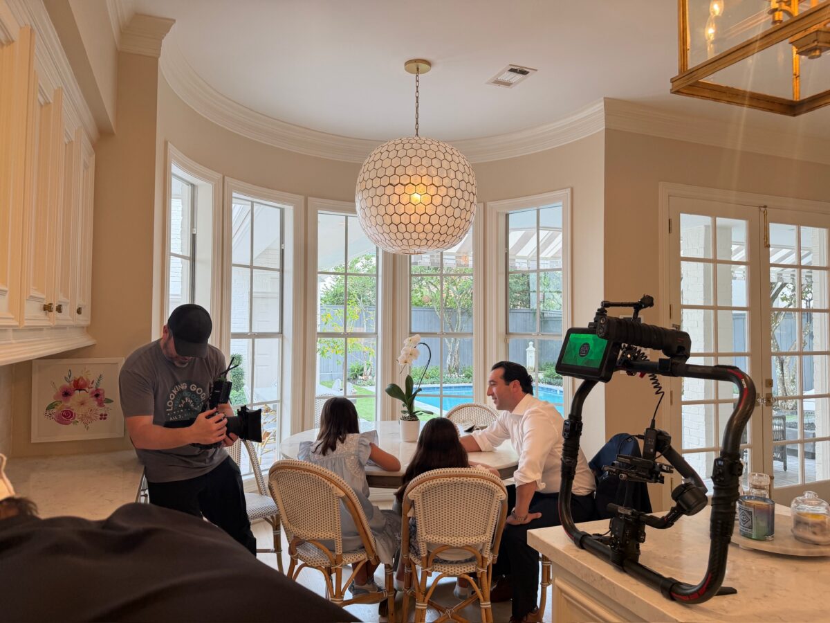 Film crew capturing client testimonial scene in home kitchen