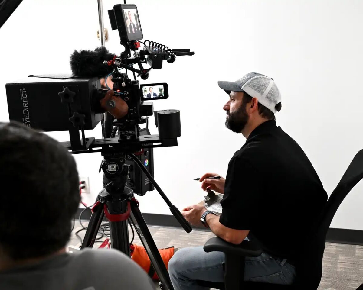 Director reviewing attorney interview footage on camera setup