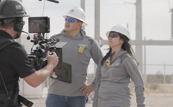 Zach Jankovic films a male and female employee looking around a power station