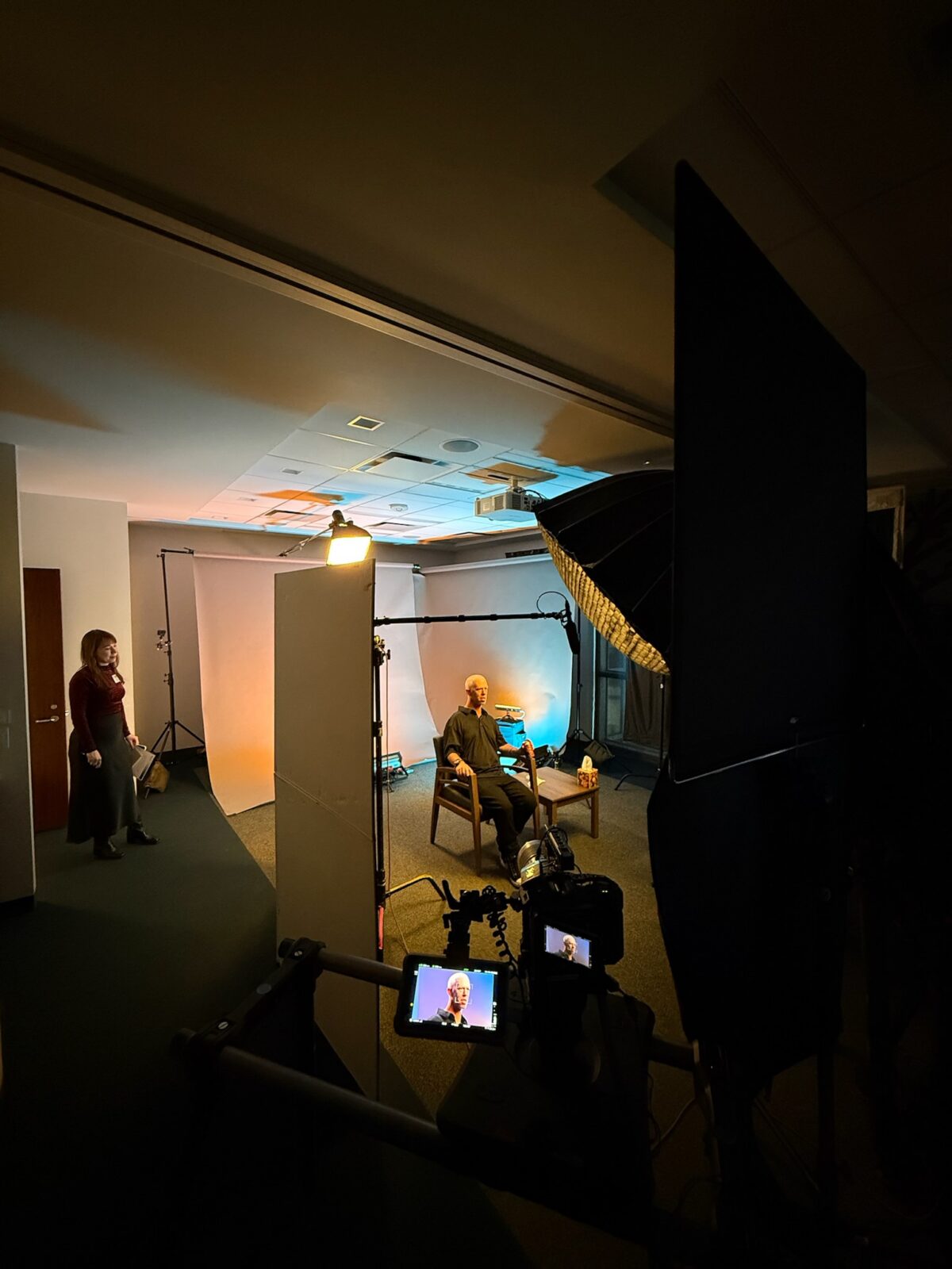 A man sits in a room prepared for a single interview set-up, behind the scenes of Cut To Create's project for Rice University's Kinder Institute for Urban Research