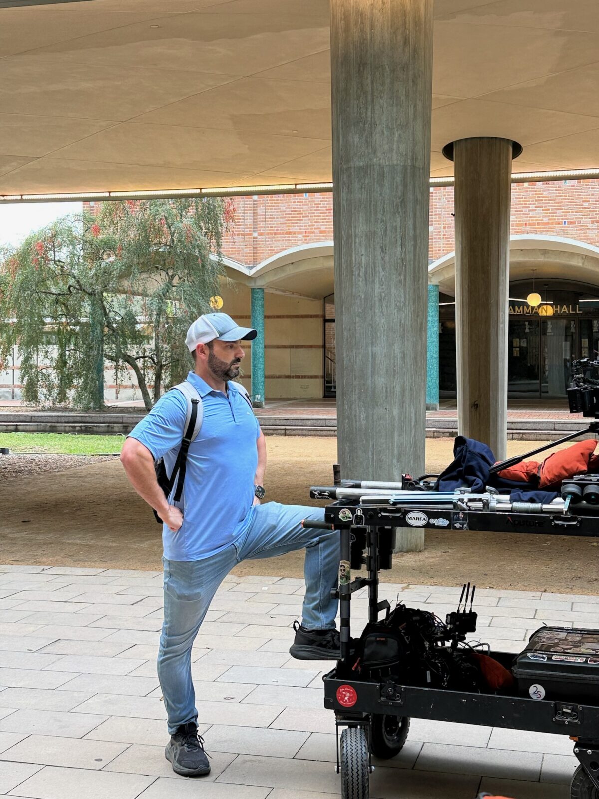 Zach Jankovic standing proud next to a production cart on Rice University Campus