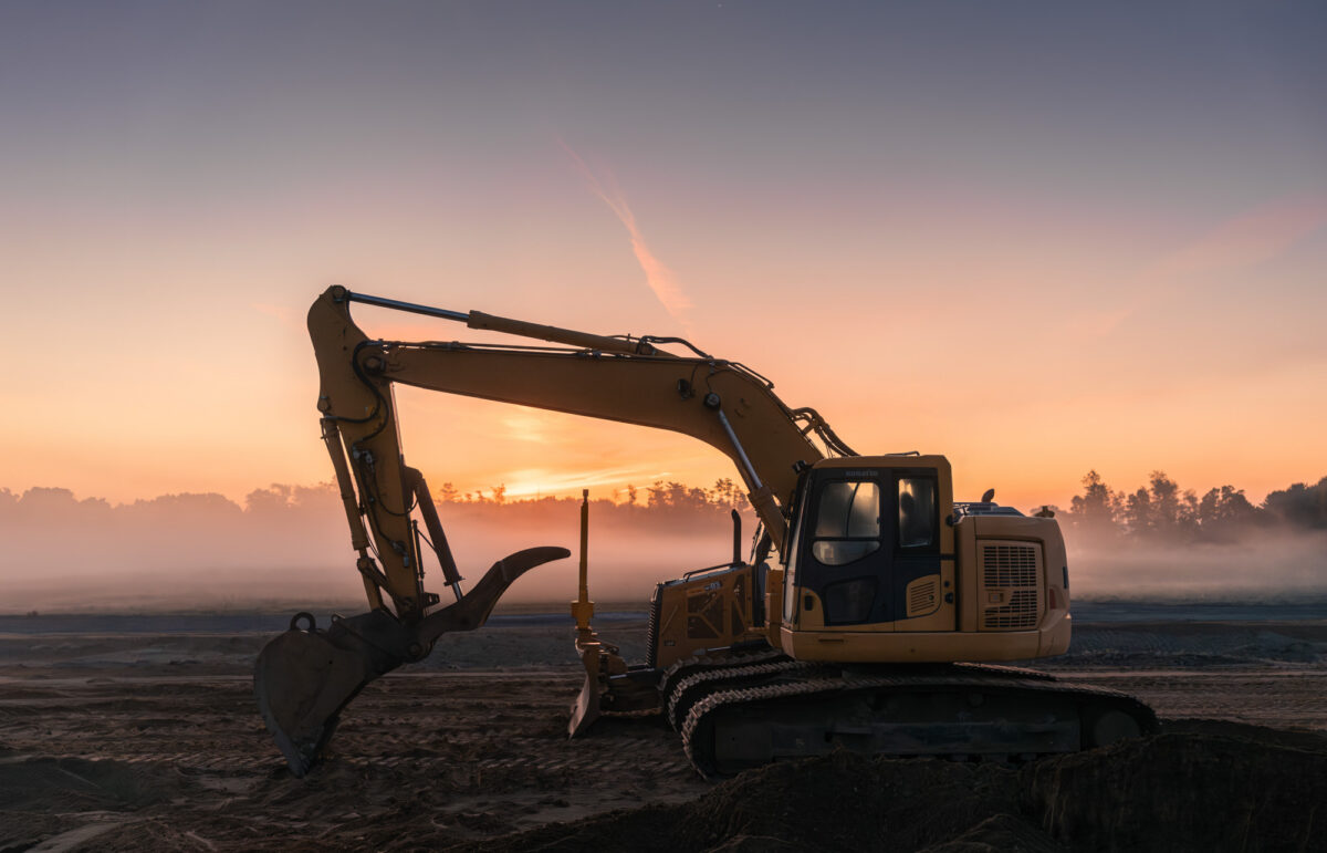 Dramatic backlit photo of a excavator at sunset